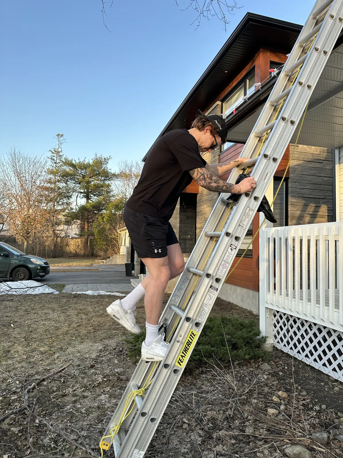 Holiday lights being installed along a house roofline